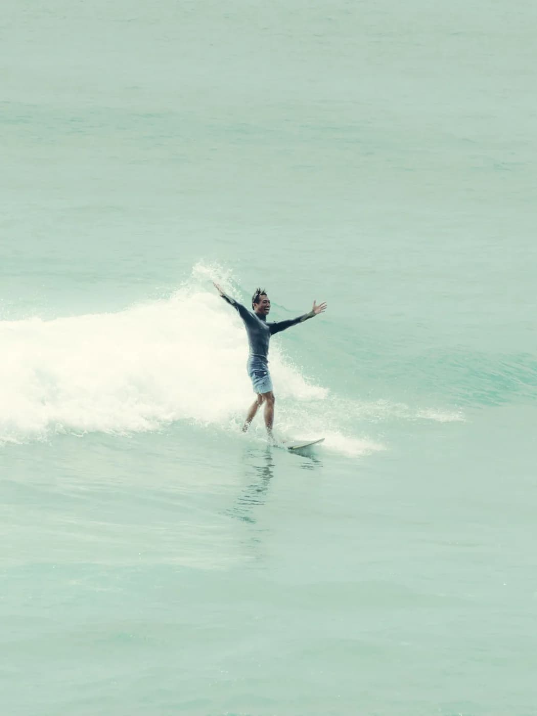 Surfer balancing on a breaking tropical wave